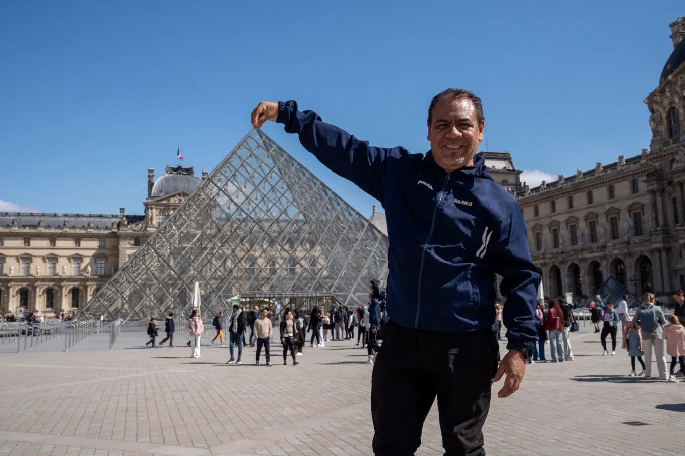 Luis, tour leader da UP Level, em frente à pirâmide do Louvre, em Paris